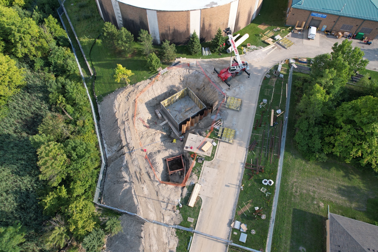 Aerial overview of excavation work beside an existing facility